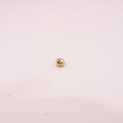 a close up of a gold ball on a white surface