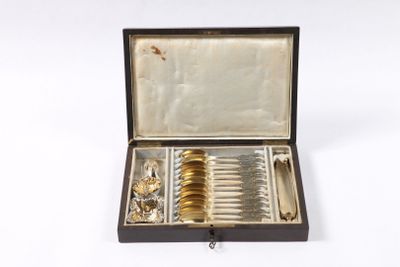 une boîte ouverte contenant des couverts, posée sur une surface blanche