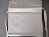 a white purse sitting on a table next to a brown purse