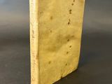 an old yellow book sitting on top of a black table
