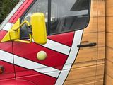 a red and yellow truck with a surfboard on the back
