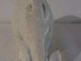 a white ceramic elephant figurine sitting on a white cloth