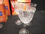 three wine glasses sitting on a table next to a box of oranges
