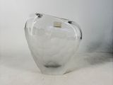 a clear glass vase with a gold label on it