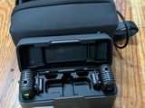 une mallette noire contenant une radio, posée sur une table en bois
