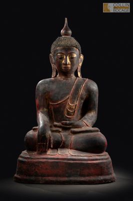 une statue de Bouddha assis sur un socle en bois