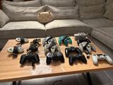 many video game controllers on a table in front of a couch