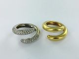 two gold and silver rings with diamonds on a white surface