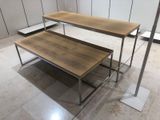 two tables that are sitting on the floor in the room