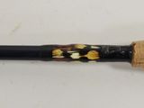 a close up of a fishing rod on a white surface