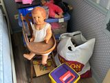 une poupée assise dans une chaise haute dans un coin de la pièce