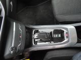 an image of a car ' s center console with a cell phone in it
