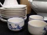 a lot of dishes and cups sitting on a table