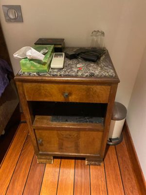 a nightstand with a phone on top of it on a wooden floor