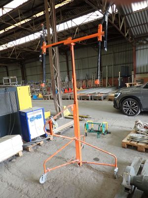 a car parked in a warehouse with a crane in the middle of it