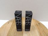 two black boxes of nars cosmetics on a wooden table