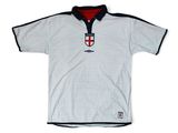 Le maillot est blanc et noir, avec un écusson rouge et blanc.