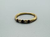 une image représentant une bague en or sertie de diamants noirs et blancs
