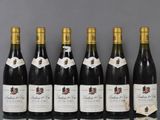 six bottles of wine are lined up in a row on a table