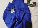a pair of blue pants and a pair of sunglasses on a bed
