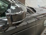 a man that is painting the side of a car