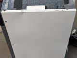 a white dishwasher sitting on the floor next to a black and white dishwasher