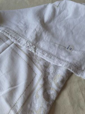 un gros plan sur un pantalon blanc posé sur un lit