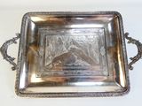 un plateau en argent orné d'une image, posé sur une table