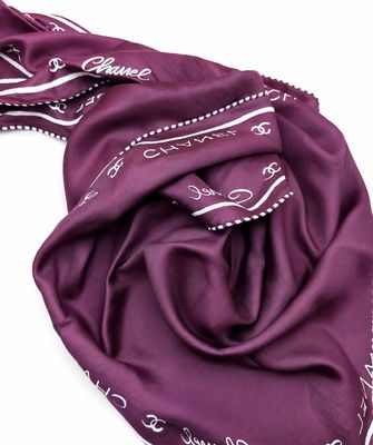L'écharpe violette est posée sur une surface blanche.