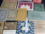 Plusieurs livres sont alignés sur une table devant un fond bleu.