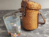 a wicker bag and a glass on a table