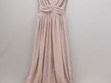 the back of a dress hanging on a hanger in front of a white wall