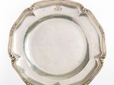 an antique silver plate on a stand on a white background