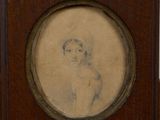 une vieille photo représentant un jeune garçon coiffé d'un chapeau, dans un cadre en bois