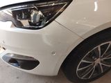 a close up of a white car that is parked in a garage