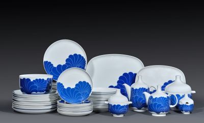 Des assiettes et des tasses bleues et blanches sont disposées sur une surface grise