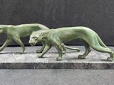 two statues of a dog and a cat on a marble base