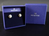une paire de boucles d'oreilles dans une boîte bleue posée sur une table