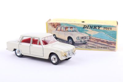 a small toy car in front of a box of dinky toys