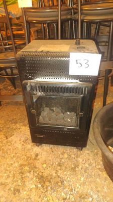 a stove that is sitting in a room with chairs