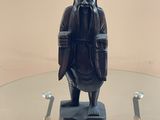 une statue représentant un homme assis sur une table en verre