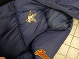 a person wearing a blue jacket with patches on it