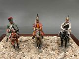 three figurines of men riding horses in a display case