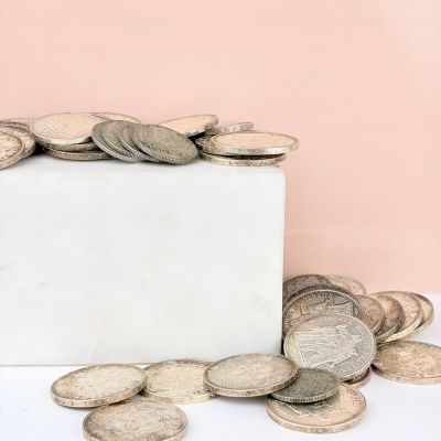 a white marble block with a pile of coins on top of it
