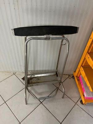 a metal stool and a shelf in the corner of a room