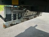 le dessous d'un camion rouillé, avec un téléviseur à l'arrière