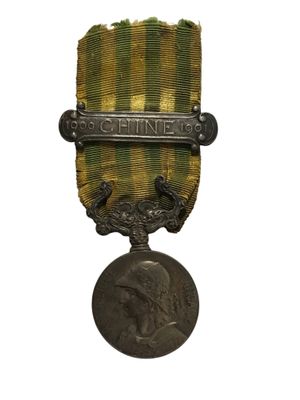 une vieille médaille surmontée d'une autre médaille, sur fond blanc