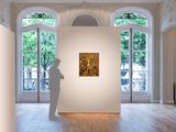 a sculpture in the middle of a room with a painting on the wall