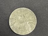 a close up of a silver coin on a black surface