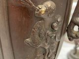 a bronze vase with a bird on it on a table